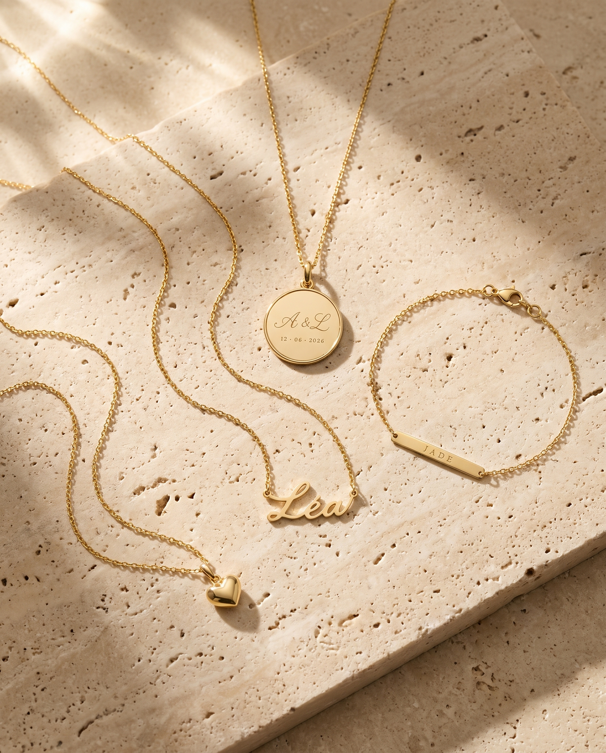 Médaille, collier prénom, bracelet gravé et collier cœur sur pierre de travertin